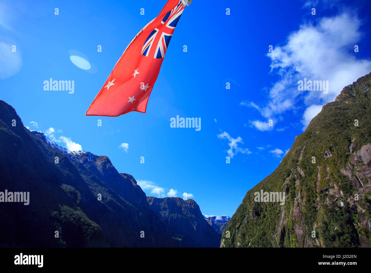 La Nouvelle Zélande drapeau flotte maritime au large de la poupe d'un bateau de croisière sur le Milford Sound, dans l'île du sud de Nouvelle-Zélande. Banque D'Images