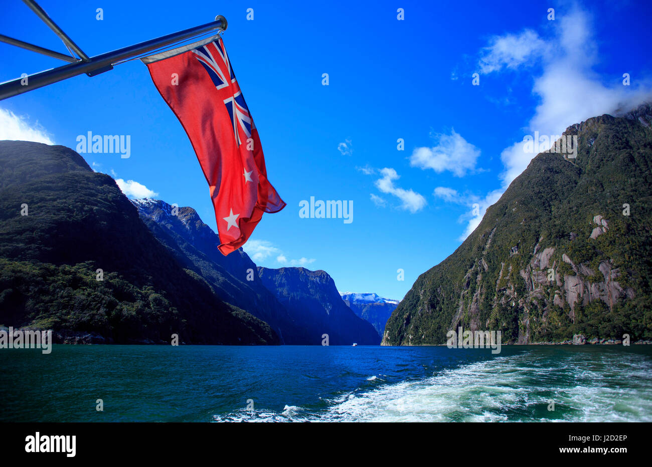 La Nouvelle Zélande drapeau flotte maritime au large de la poupe d'un bateau de croisière sur le Milford Sound, dans l'île du sud de Nouvelle-Zélande. Banque D'Images