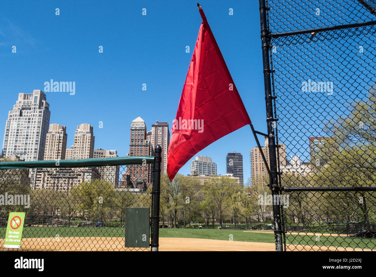 Drapeau rouge à Heckscher Ballfields symbolisant "Fermé pour jouer' Central Park au printemps, New York City, USA Banque D'Images