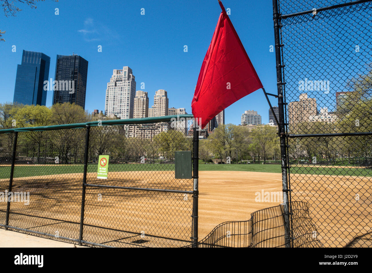 Drapeau rouge à Heckscher Ballfields symbolisant "Fermé pour jouer' Central Park au printemps, New York City, USA Banque D'Images