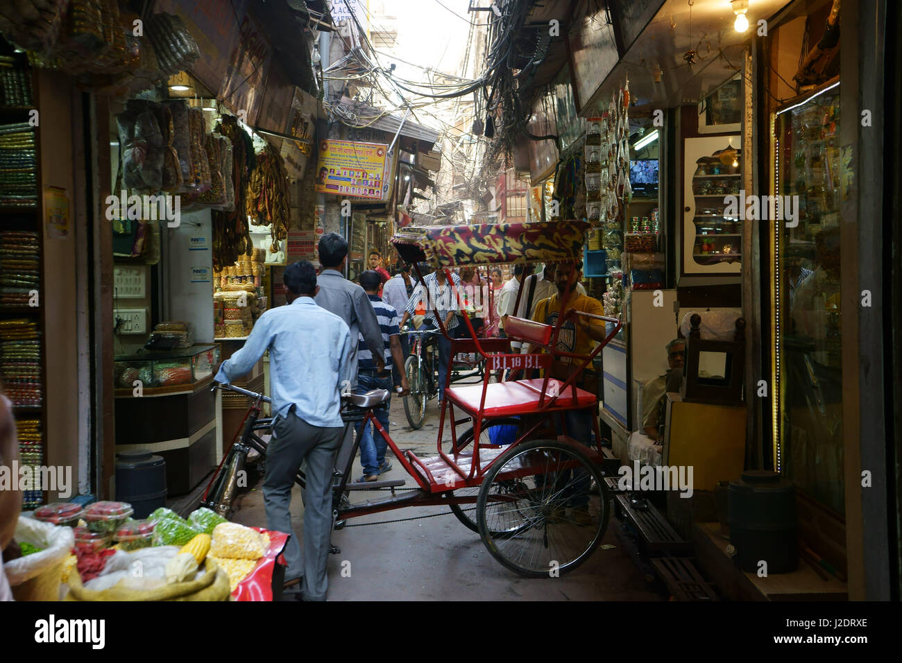 Rue étroite avec de petits magasins qui vendent des épices dans Old Delhi rempli de rikshas et personnes, Inde Banque D'Images