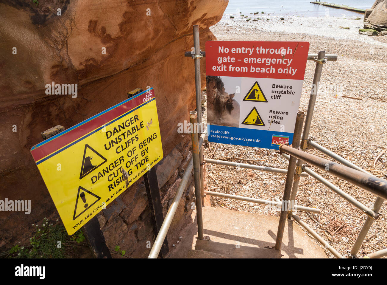 Signes d'avertissement à côté de l'instabilité de falaises de Sidmouth, qui souvent fracture et tombent sur la plage ci-dessous. Banque D'Images