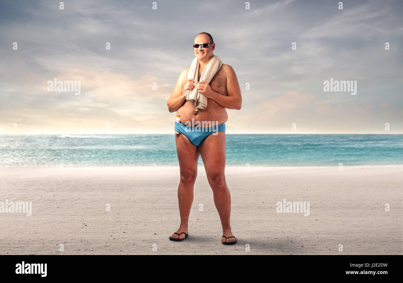 Gros homme debout sur la plage Banque D'Images