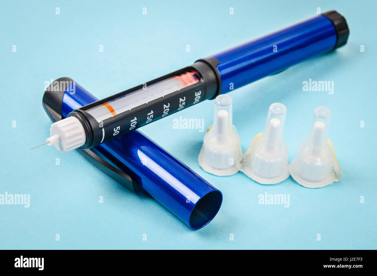 Stylo à insuline remplir d'aiguille sur fond bleu. Banque D'Images
