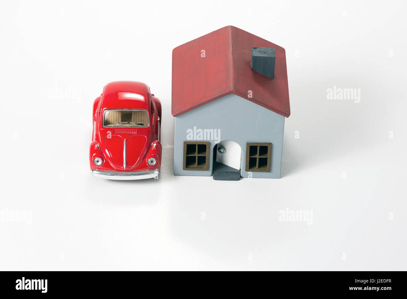 Izmir, Turquie - 1 avril 2017 : petite voiture rouge et miniature house sur un fond blanc. Banque D'Images