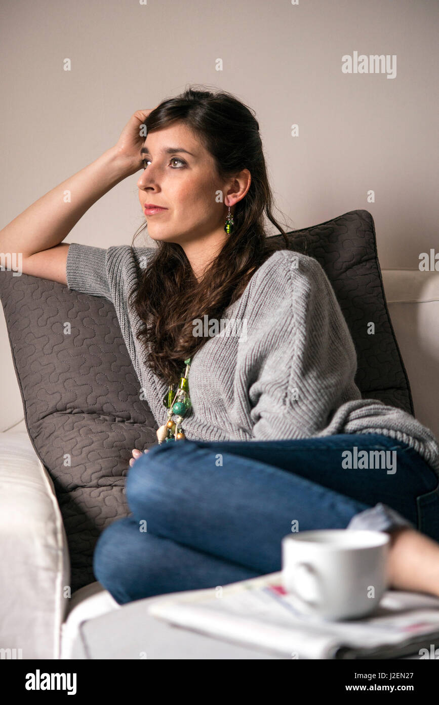 Young Adult Woman Relaxing on Sofa Banque D'Images