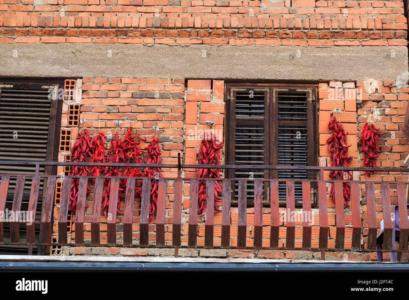 Macédoine, Ohrid, Ohrid, Ohrid, le village de Vevcani est dans le sud-ouest de l'aire de répartition de la Nišava montagnes, près de Skopje. Magasin local dries piment rouge sur mur de brique. Banque D'Images