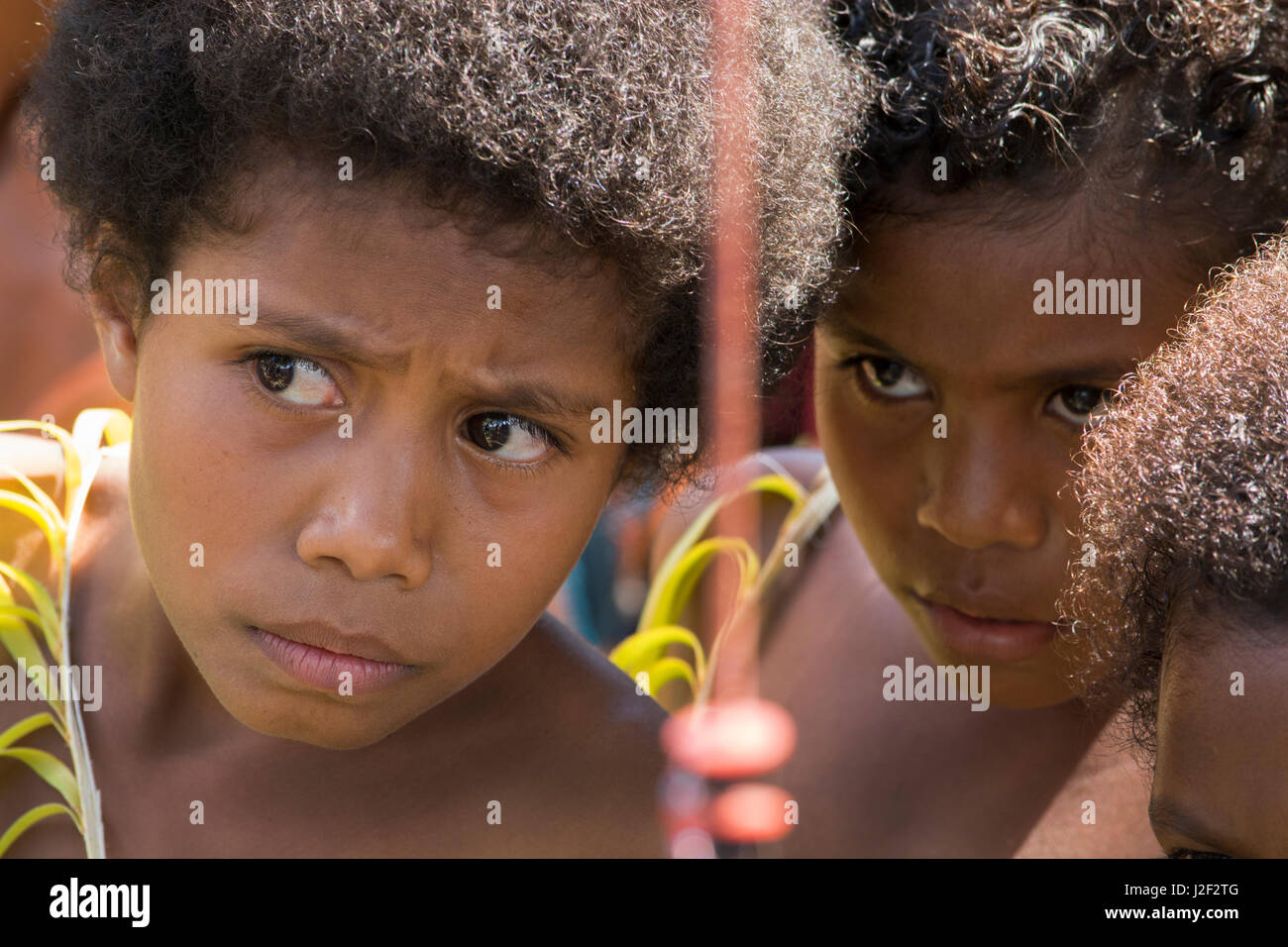 En Mélanésie, la Papouasie-Nouvelle-Guinée, l'île de Dobu. Les enfants des villages indigènes en tenue de palm. Banque D'Images