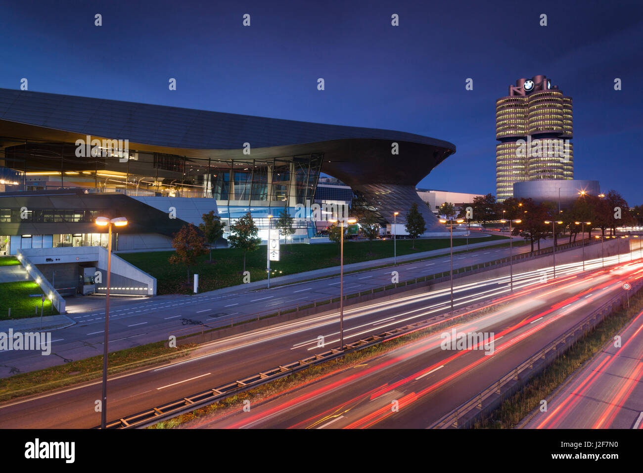 Germany, Bavaria, Munich, BMW Welt showroom de l'entreprise, siège de l'entreprise BMW et BMW Museum avec trafic du soir Banque D'Images