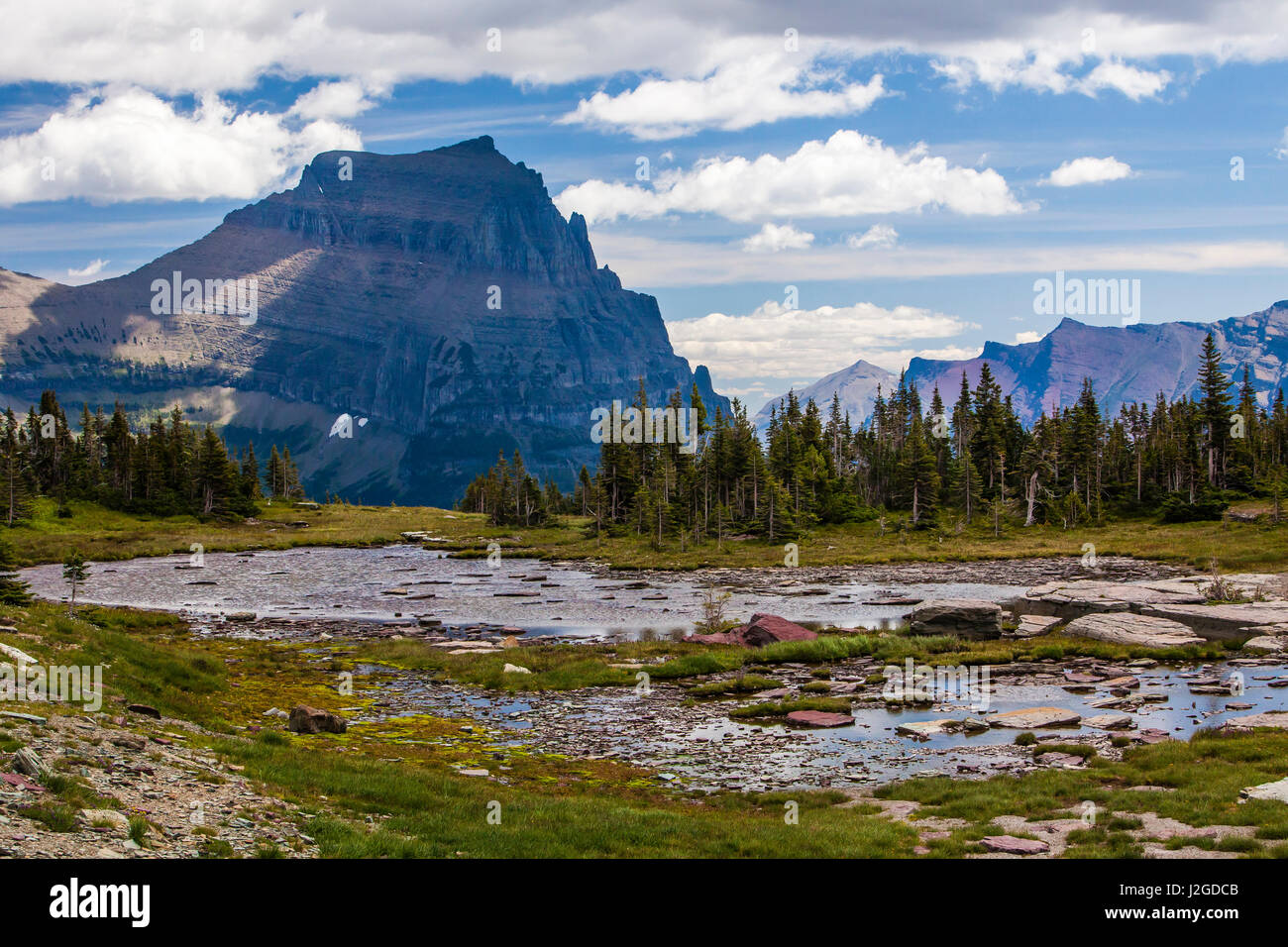 Le parc national des Glaciers. Petite piscine et les Pics de Lewis sur la plage donnent sur Hidden Lake Trail Banque D'Images