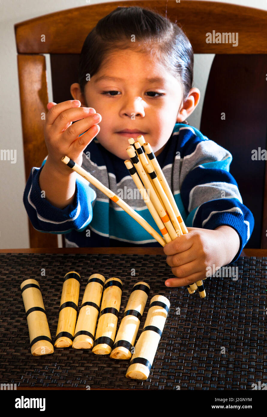 Native American enfant apprend à compter en utilisant des paquets de bois peint qui étaient des jouets traditionnels de beaucoup de tribus des Grandes Plaines (MR) Banque D'Images