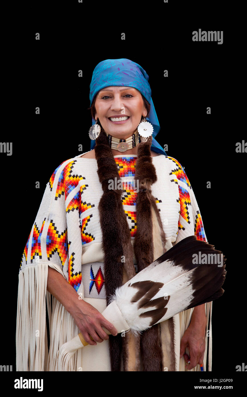 Habillé traditionnellement Shoshone Bannock, Shirley Alvarez, sourit tandis qu'elle pose sur un fond noir pendant le festival indien Shoshone Bannock, Fort Hall New York Banque D'Images