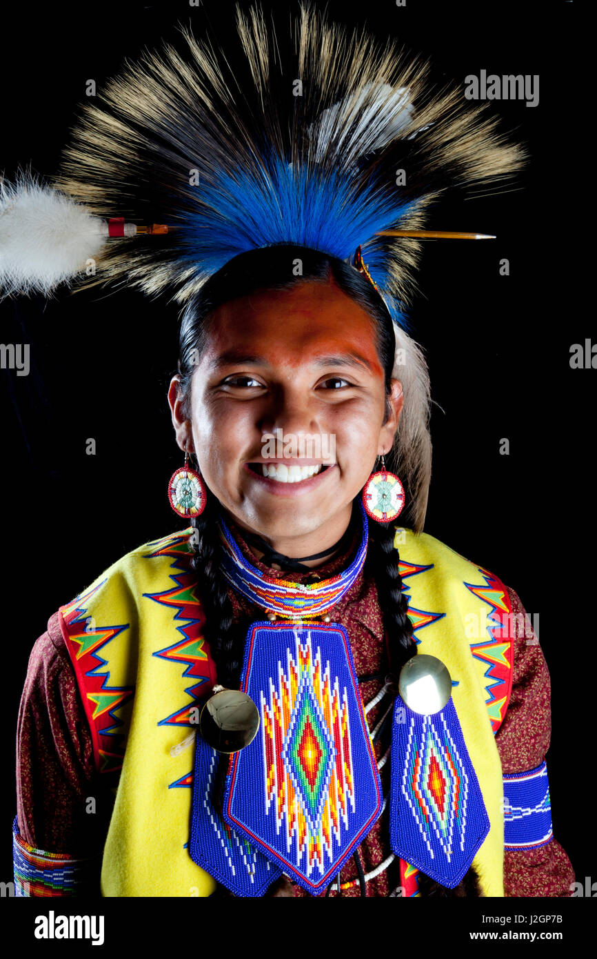 Teenage boy traditionnel habillé de pow wow regalia de perles et une coiffure roach en face de toile noire. Ian Stevens Banque D'Images