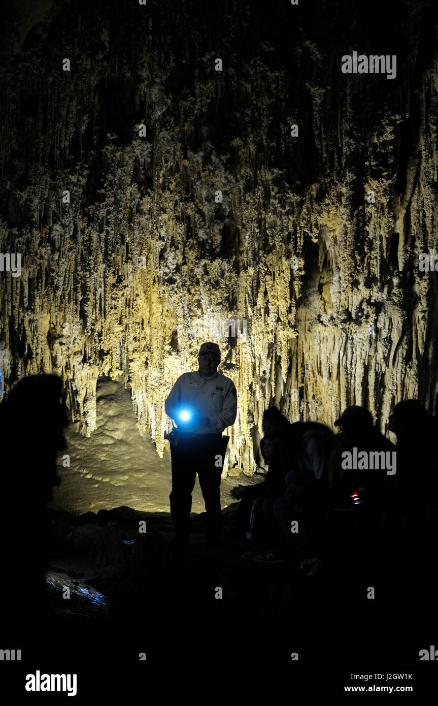 USA, Nouveau Mexique, Eddy County, Carlsbad Caverns National Park. Guide touristique avec la lumière à la Carlsbad Caverns Banque D'Images