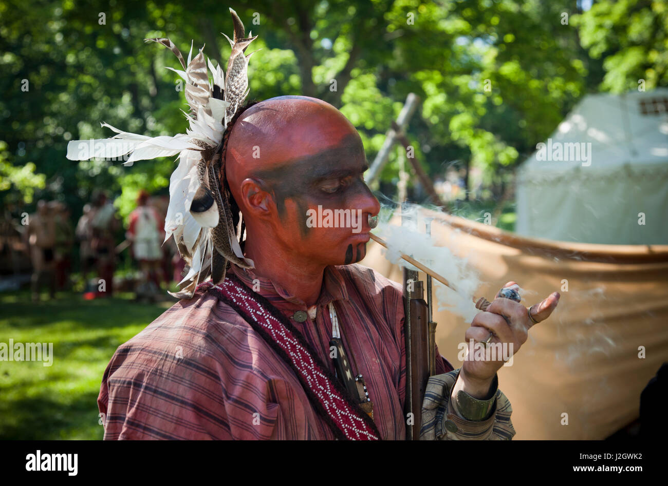 Indien de l'Amérique du nord-est de Tribes fume une pipe pendant la guerres indiennes Français Fort Niagara, NY de reconstitution Banque D'Images