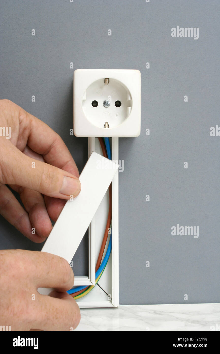 L'installation d'une prise de courant avec goulotte de câblage électrique  pour montage en surface Photo Stock - Alamy