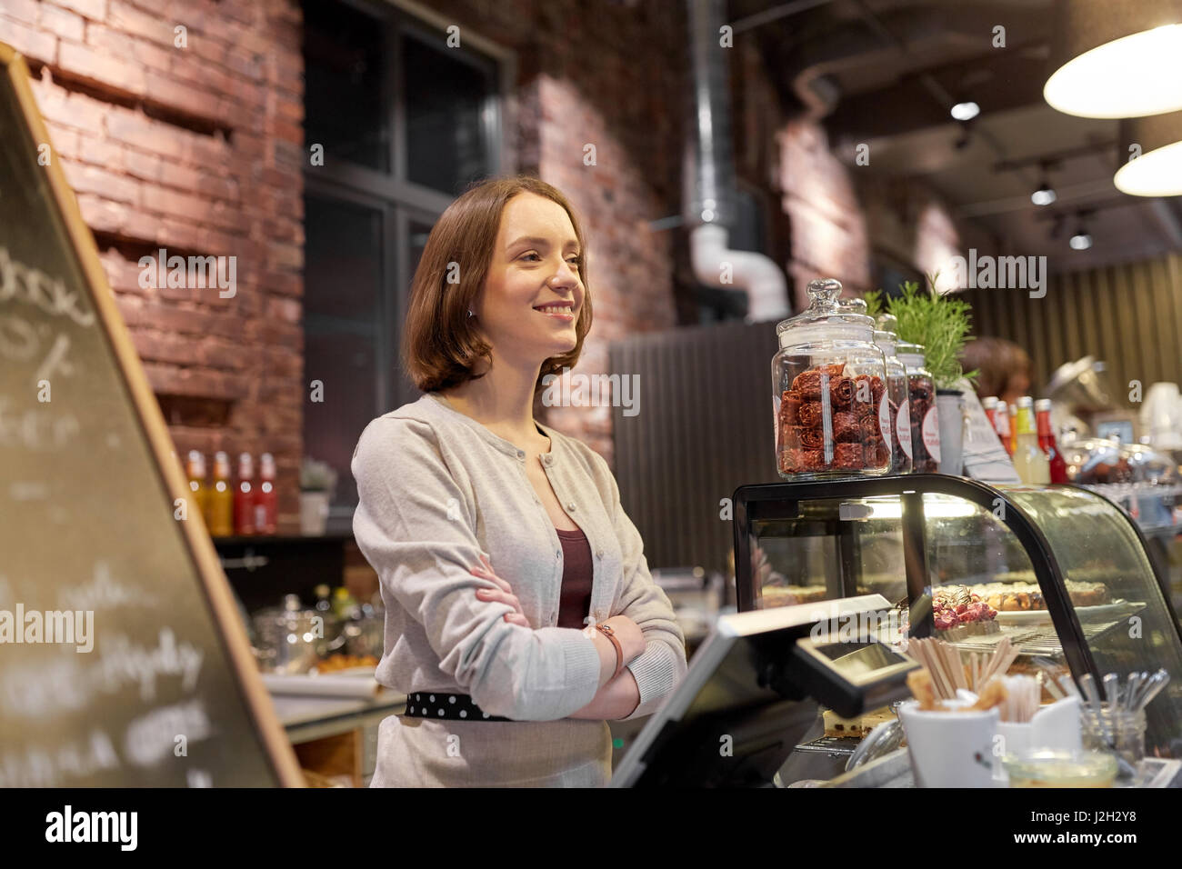 Femme heureuse ou barmaid au comptoir café Banque D'Images