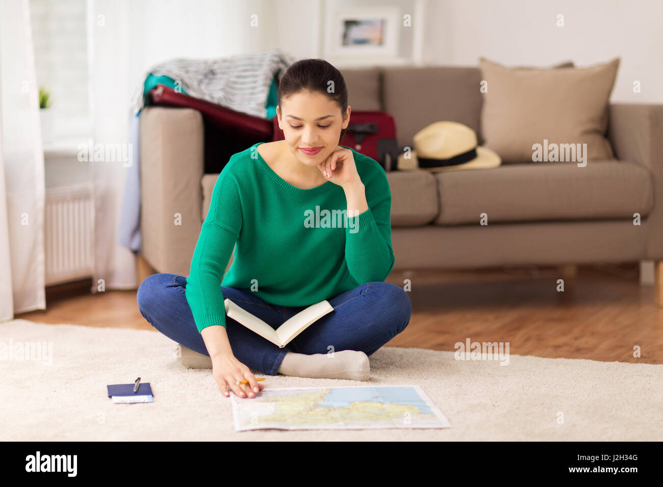 Femme avec un ordinateur portable et la carte de voyage à la maison Banque D'Images