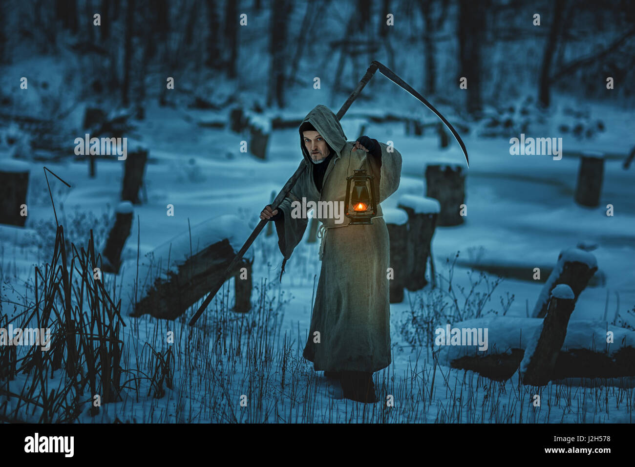 L'homme effrayant avec la faux est la neige en hiver. Banque D'Images