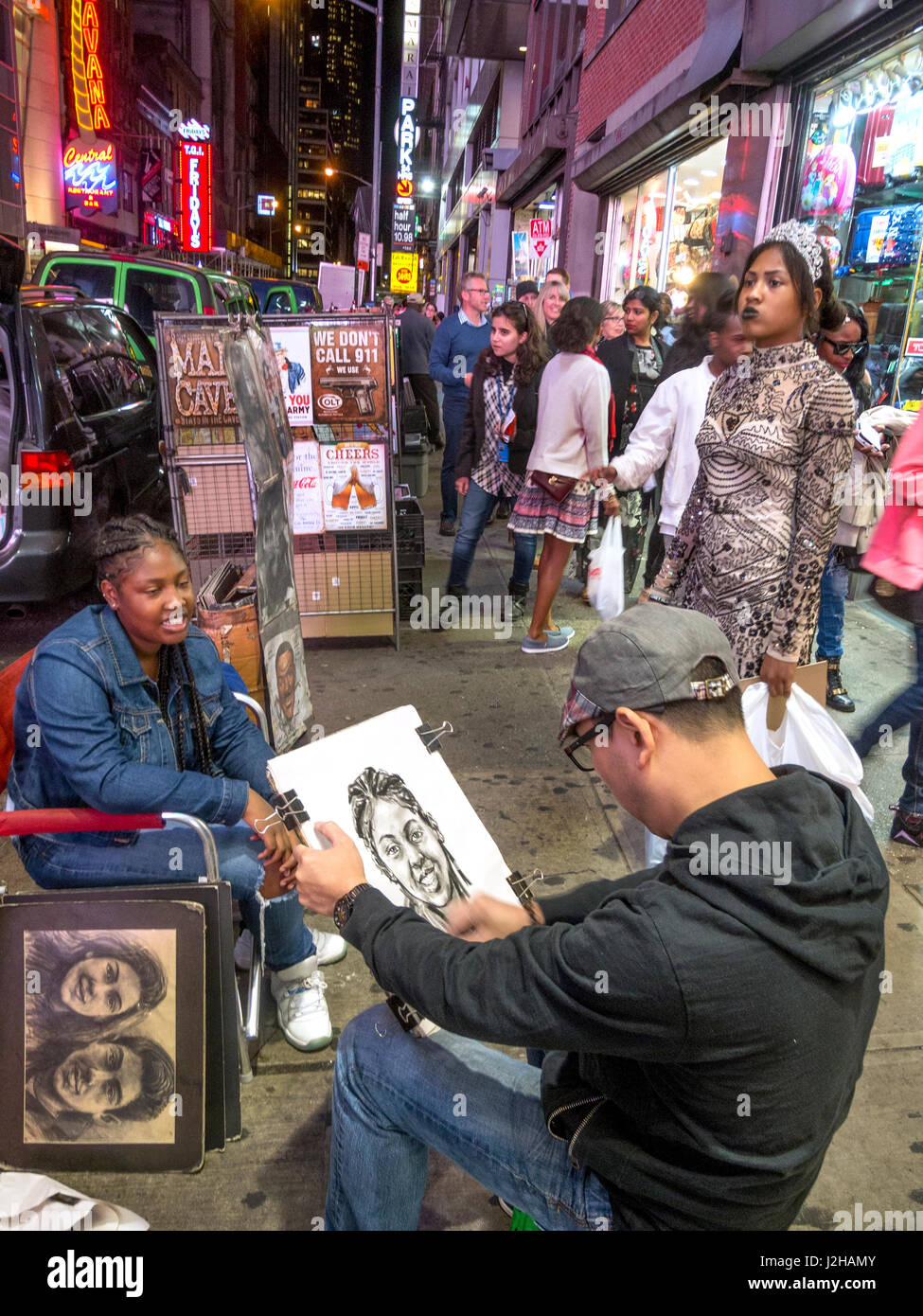 Un jeune adulte pose pour un trottoir asiatique artiste peintre à Times Square, New York City. Remarque passant le regarder travailler et d'autres négociants en arrière-plan. Banque D'Images