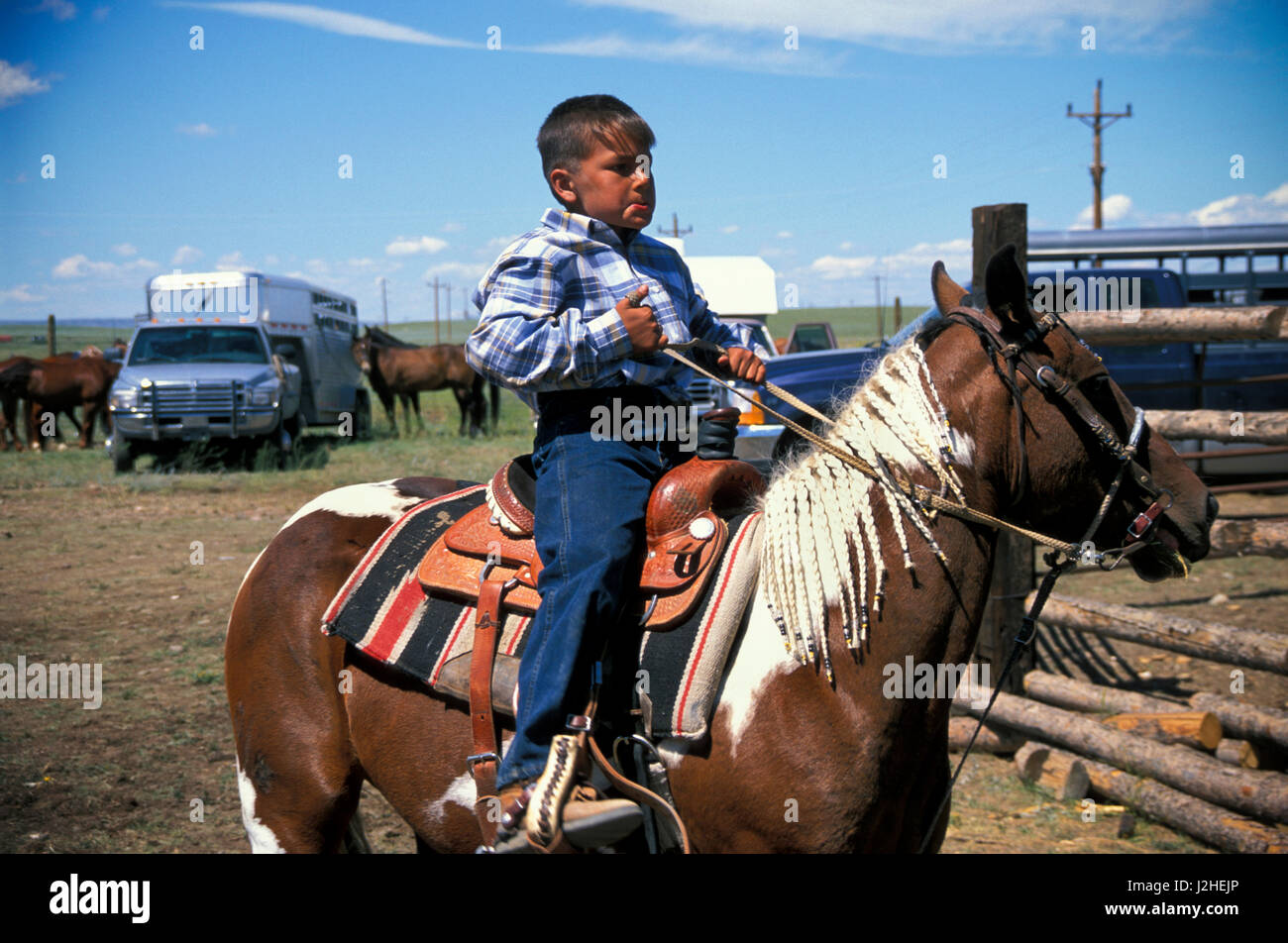 Blackfeet boy d'âge élémentaire en selle pony rides tout en regardant un rodéo indien à Browning Montana Banque D'Images