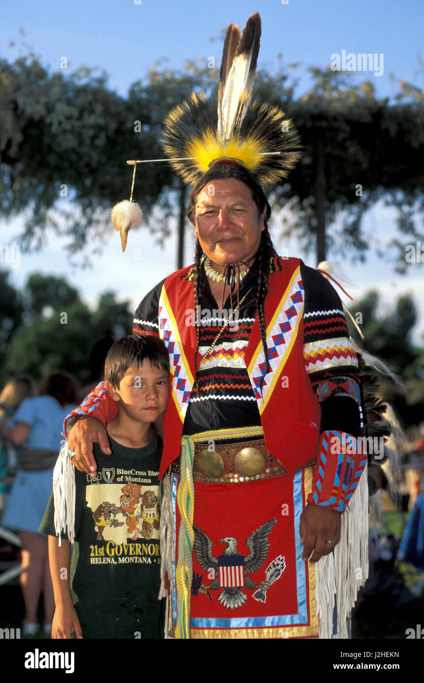 L'homme en costume traditionnel des Blackfeet jeunes mentors sur Blackfeet Reservation met bras autour de jeune garçon lors d'un rassemblement des Indiens d'Amérique (Montana) Banque D'Images