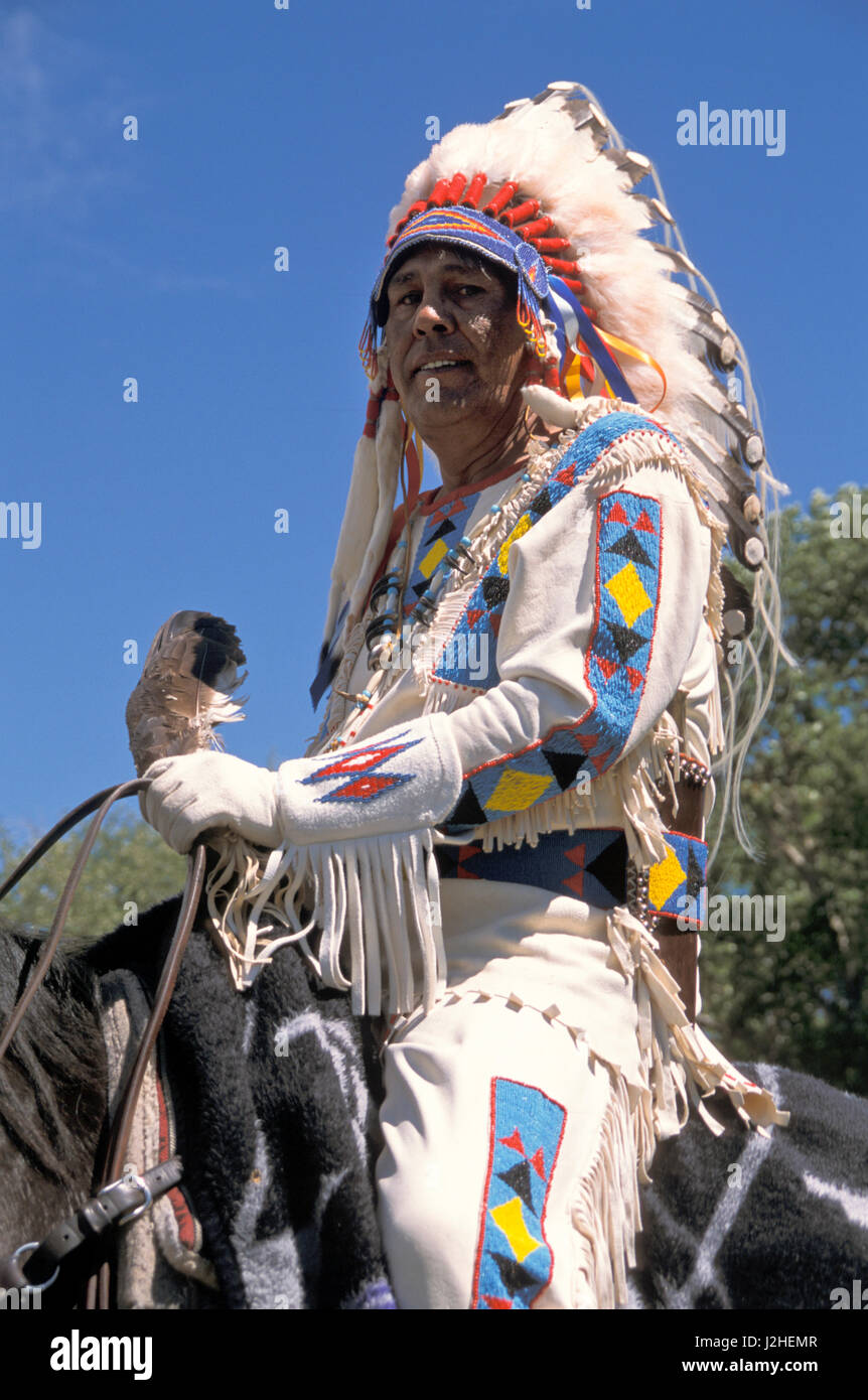 Blackfeet fièrement l'homme habillé en robe traditionnelle cerveau-tannées  chemise et le pantalon de daim frange avec le long avec une plume d'aigle  war bonnet Photo Stock - Alamy