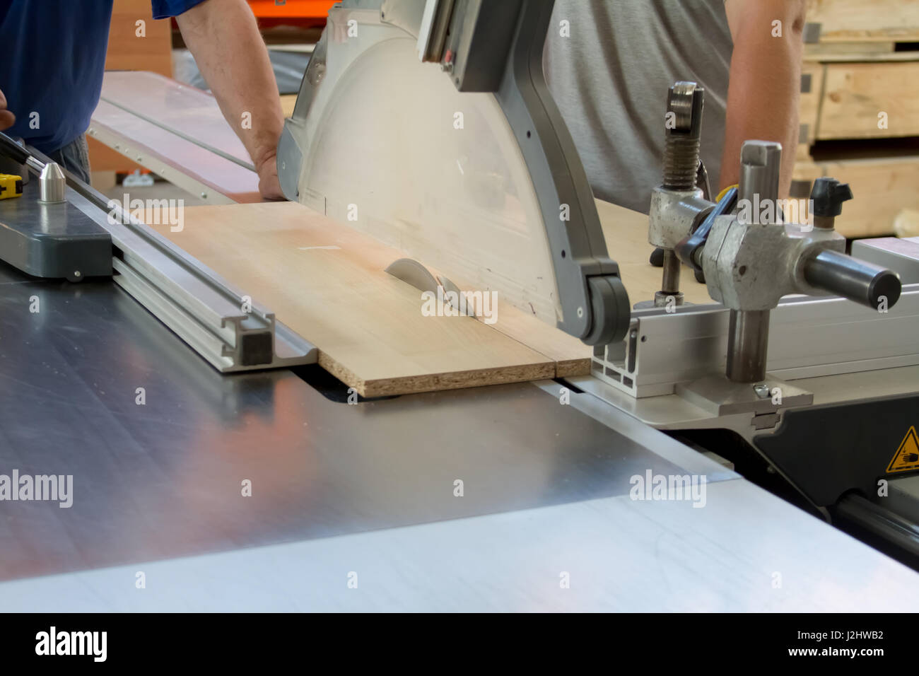 L'homme au travail scier du bois. Scie circulaire. Une machine qui scies  bois, panneaux de particules et panneaux de fibres. La production  industrielle de meubles Photo Stock - Alamy