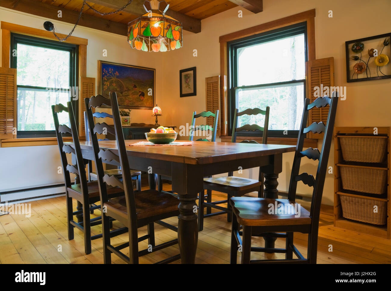Salle à manger avec table à manger en bois de style ancien et des chaises à l'intérieur d'un style cottage Canadiana log home Banque D'Images
