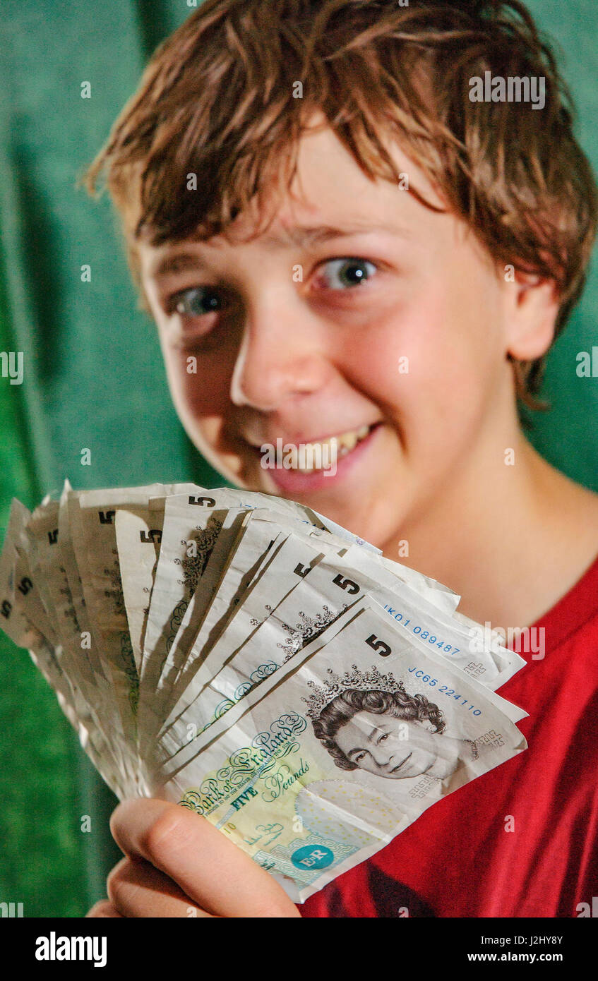 Garçon avec bande de vieilles notes cinq livres Banque D'Images