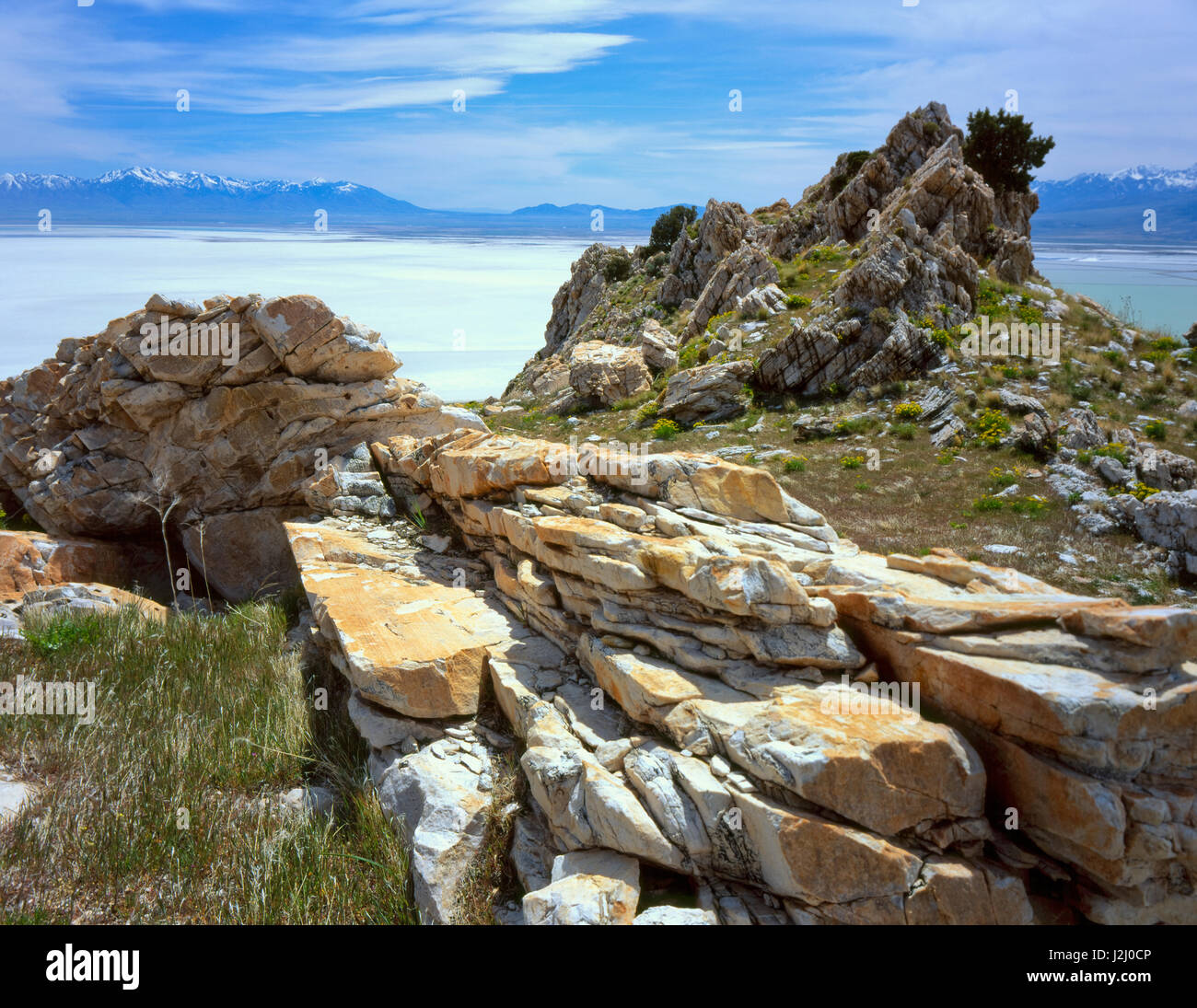 L'Utah. USA. Les affleurements érodés de quartzite sur Stansbury Island au Grand Lac Salé. Télévision sel, montagnes Oquirrh, et montagnes Wasatch à distance. Grand Bassin. Tailles disponibles (grand format) Banque D'Images