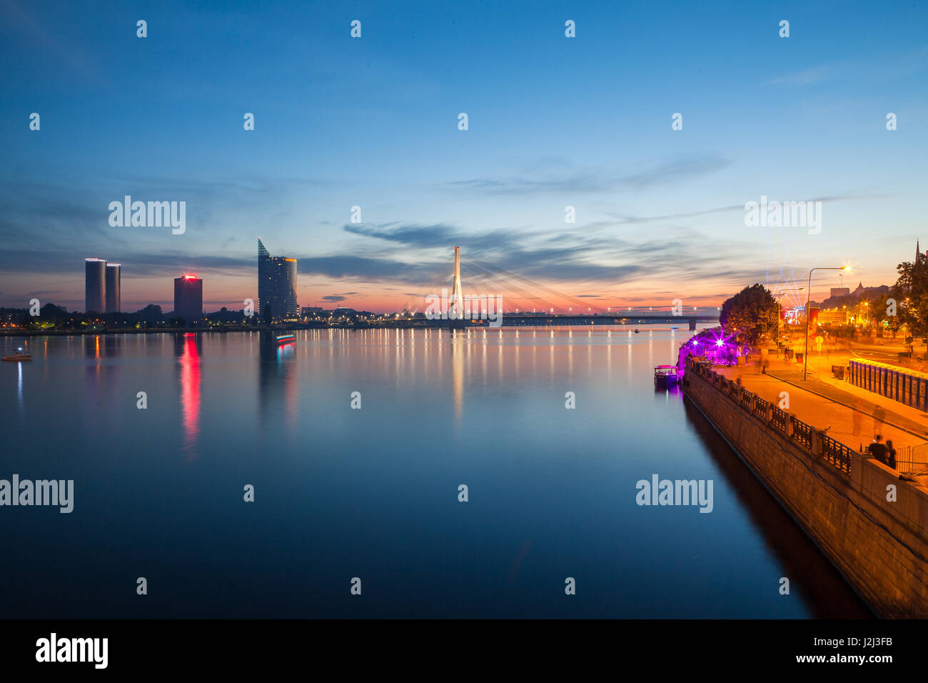 Coucher de soleil paysage panoramique, plus profonde de la rivière Daugava à Riga, Lettonie. De nouveaux bâtiments sur la gauche et de la vieille ville sur la droite. Banque D'Images