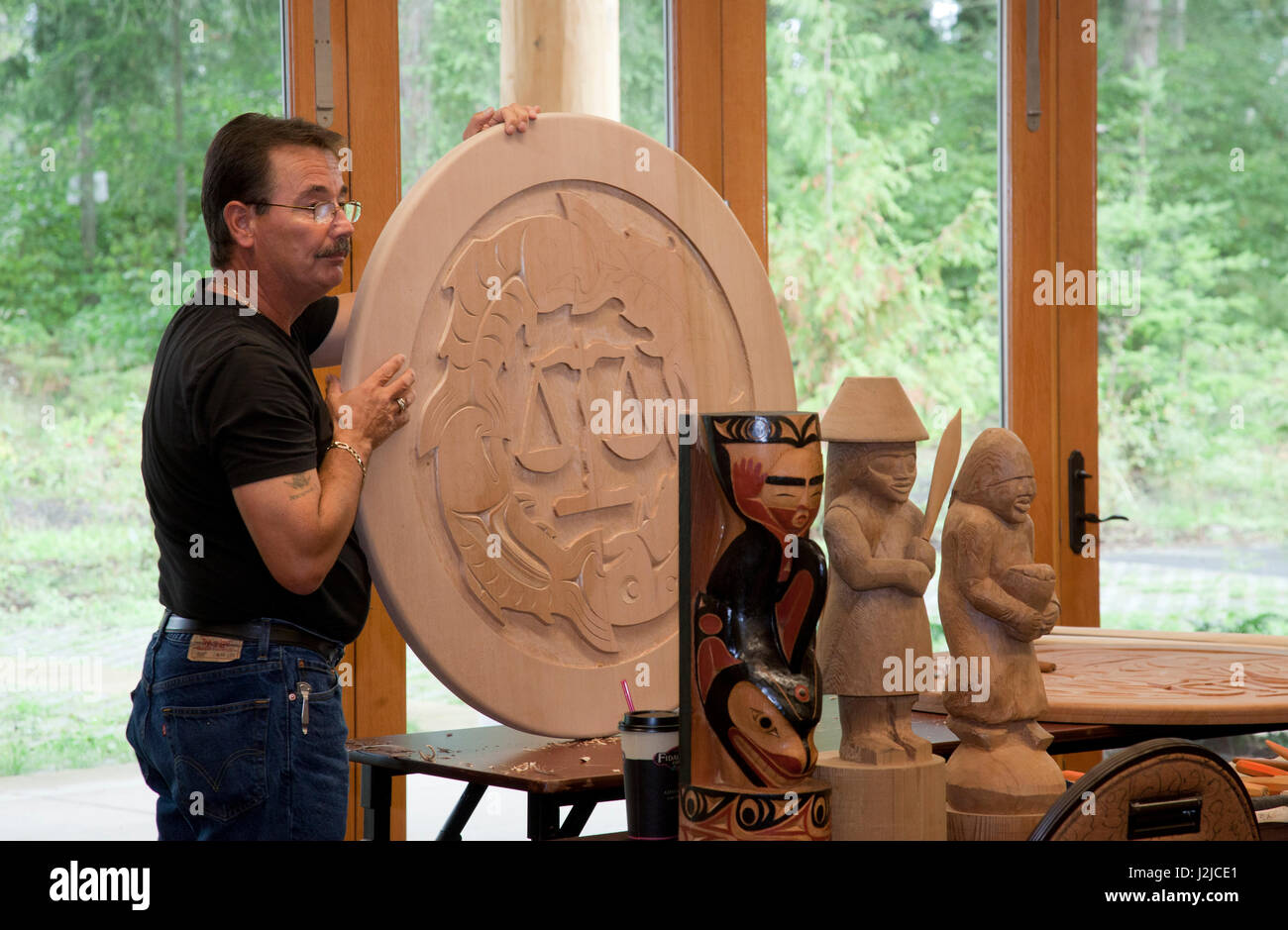 Sculpteur sur bois traditionnelles des Salish de la côte de l'affiche son savoir-faire au cours d'un atelier culturel le Hilbub Centre Culturel et Musée situé sur les Tribus Tulalip Reservation à Marysville, WA Banque D'Images