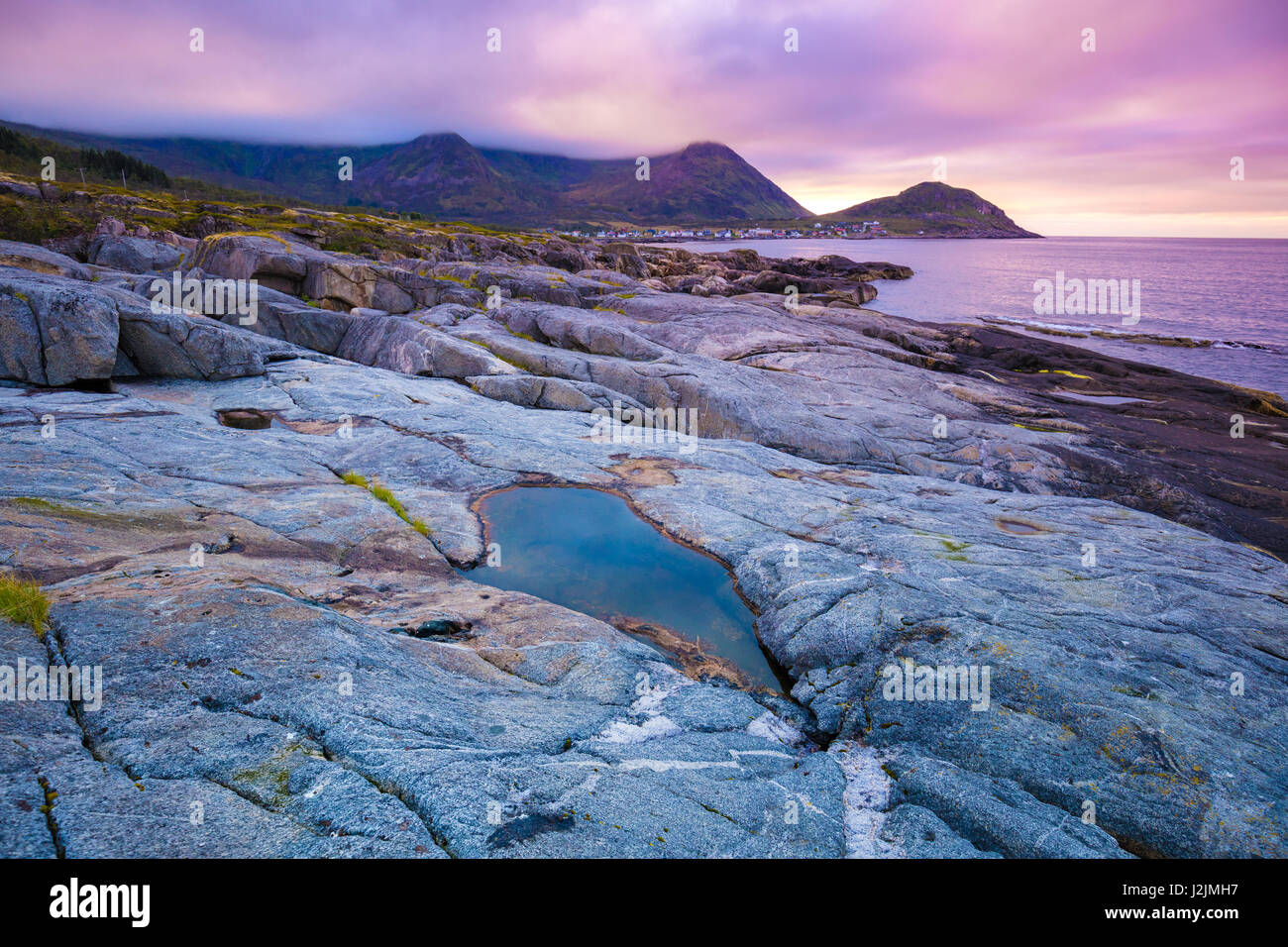 Fjord, Rocky beach at magic rose bleu coucher de soleil, la nature sauvage de la Norvège. L'île de Senja. Magnifique baie. Coucher de soleil pittoresque Banque D'Images