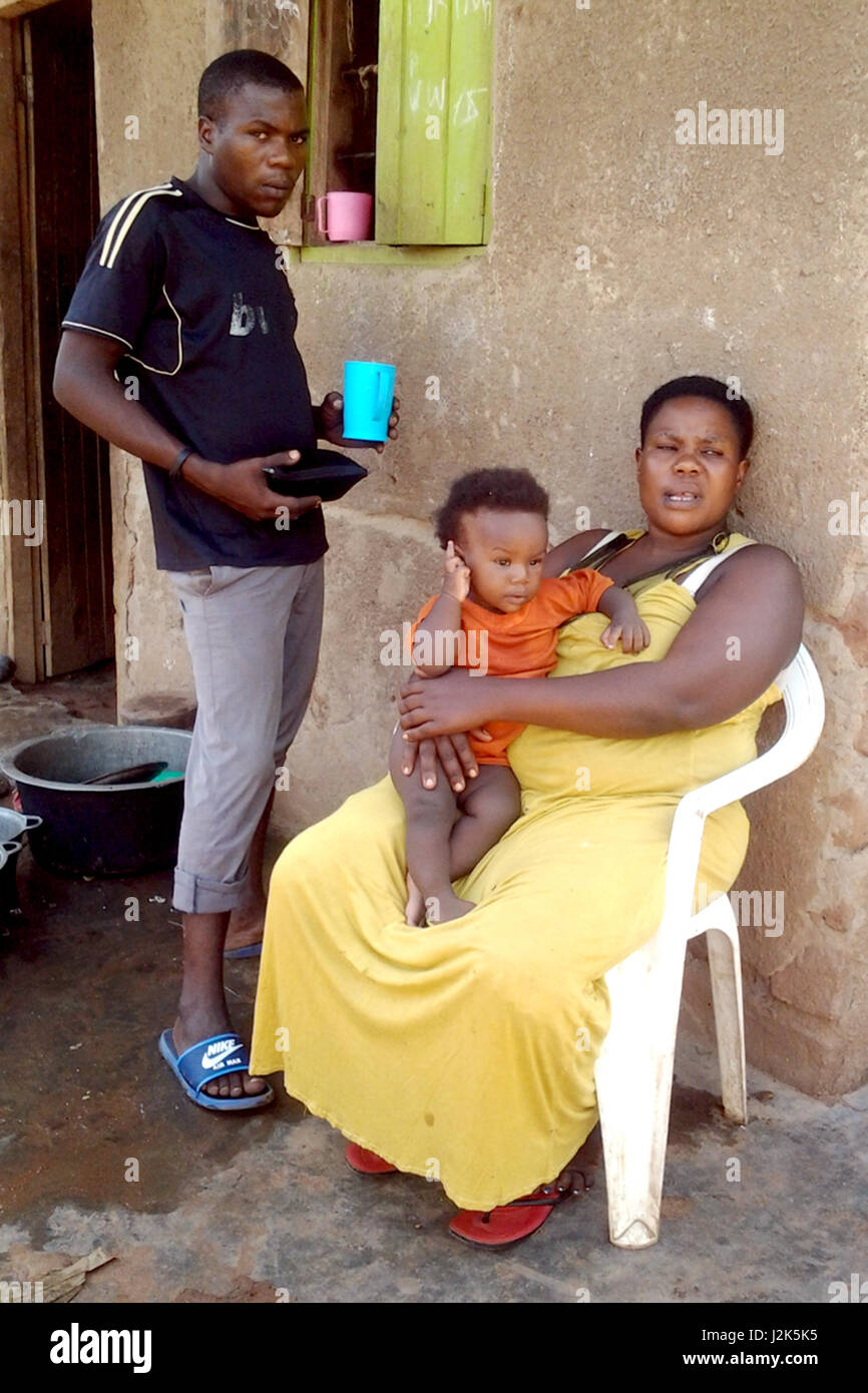 La femme ougandaise Mariam Nabatanzi se trouve en face de la maison avec  son plus jeune enfant, Sudaisha, dans Kasawo, Ouganda, 28 avril 2017. Sur  la gauche est son fils, Akim, âgé