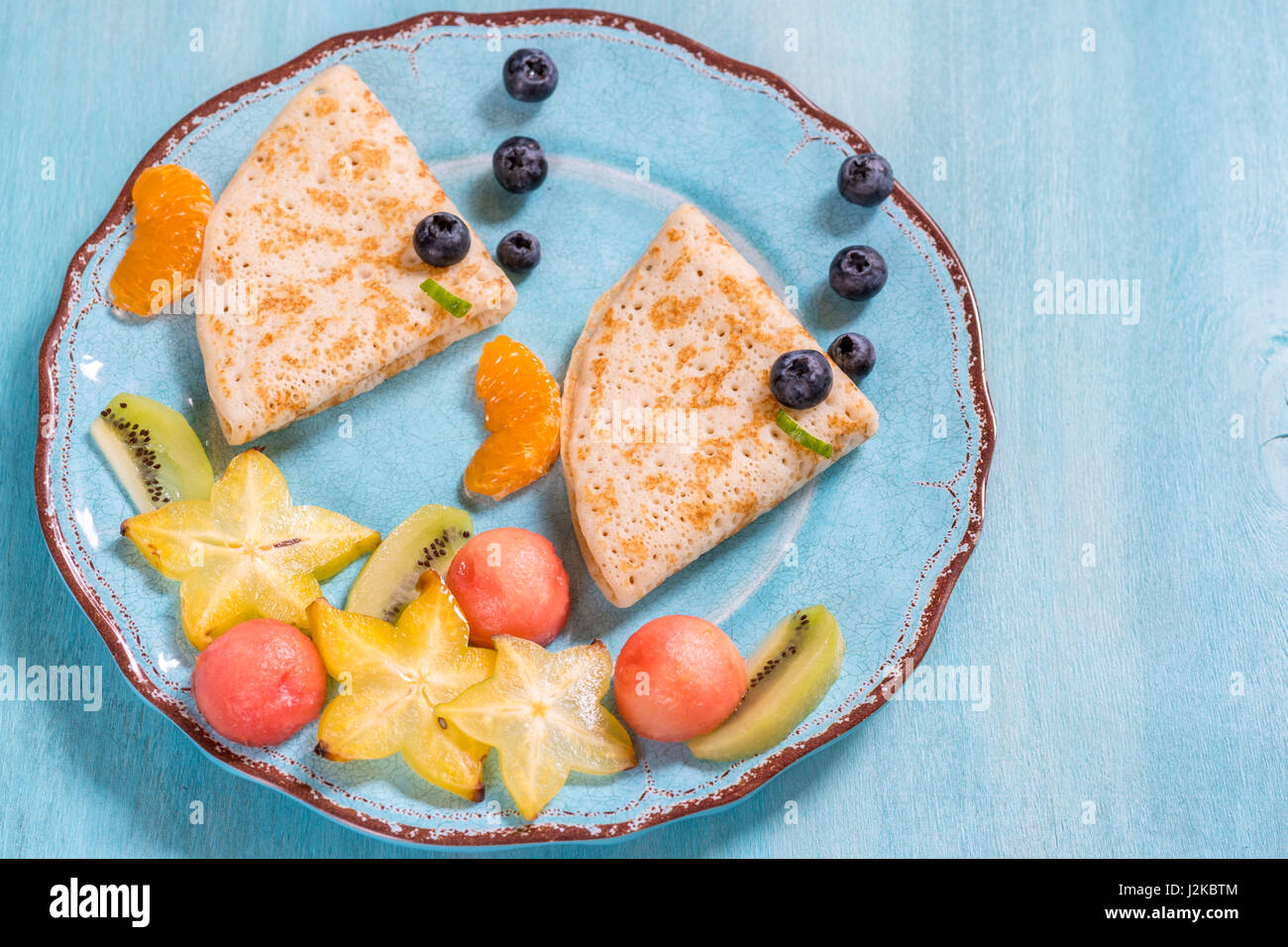 Crêpes crêpes drôle ressemble à un poisson avec des fruits pour les enfants Petit déjeuner Banque D'Images