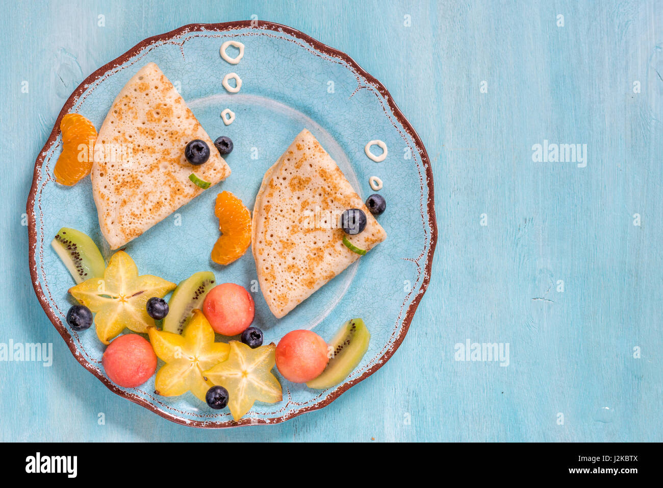 Crêpes crêpes drôle ressemble à un poisson avec des fruits pour les enfants Petit déjeuner Banque D'Images