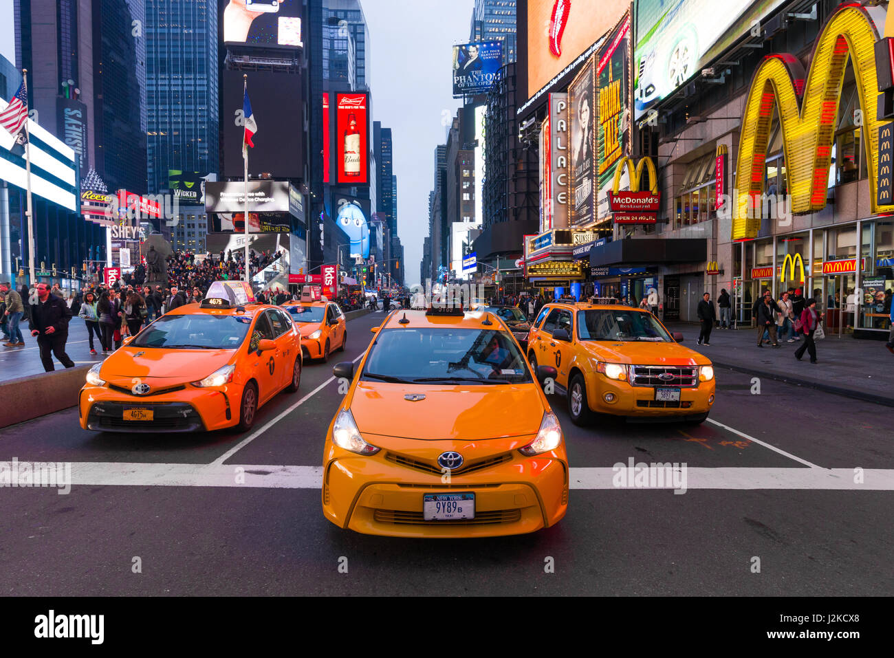 Les taxis jaunes qui attend au panneau d'arrêt en début de soirée la Lumière, Times Square, New York Banque D'Images