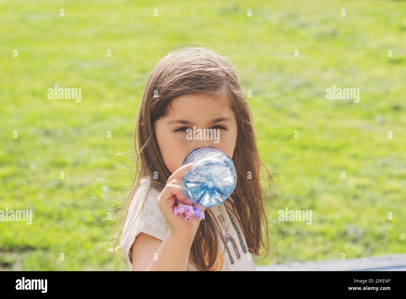 Petite fille boire l'eau de bouteille en plastique Banque D'Images