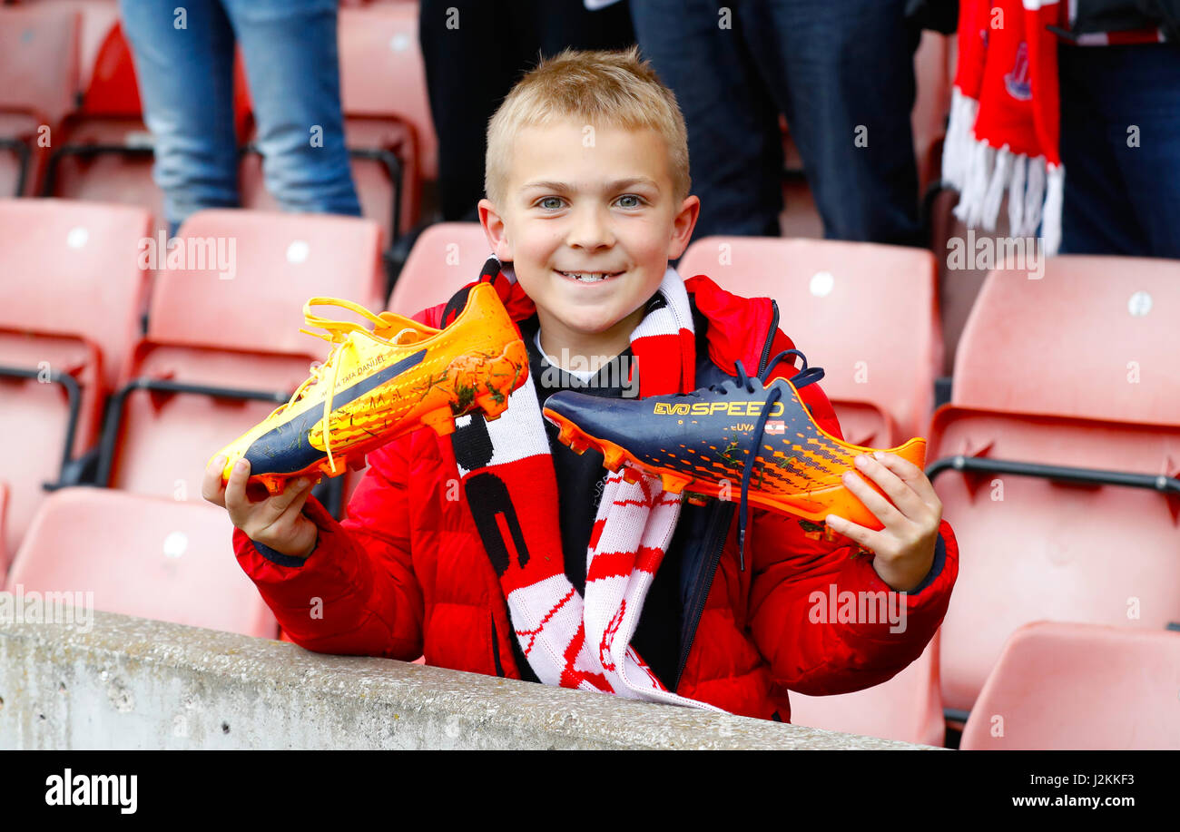 Un jeune fan Stoke tenant une paire de chaussures de foot donnée pour Stoke City's Marko Arnautovic après la Premier League match à la bet365 Stadium, Stoke. Banque D'Images