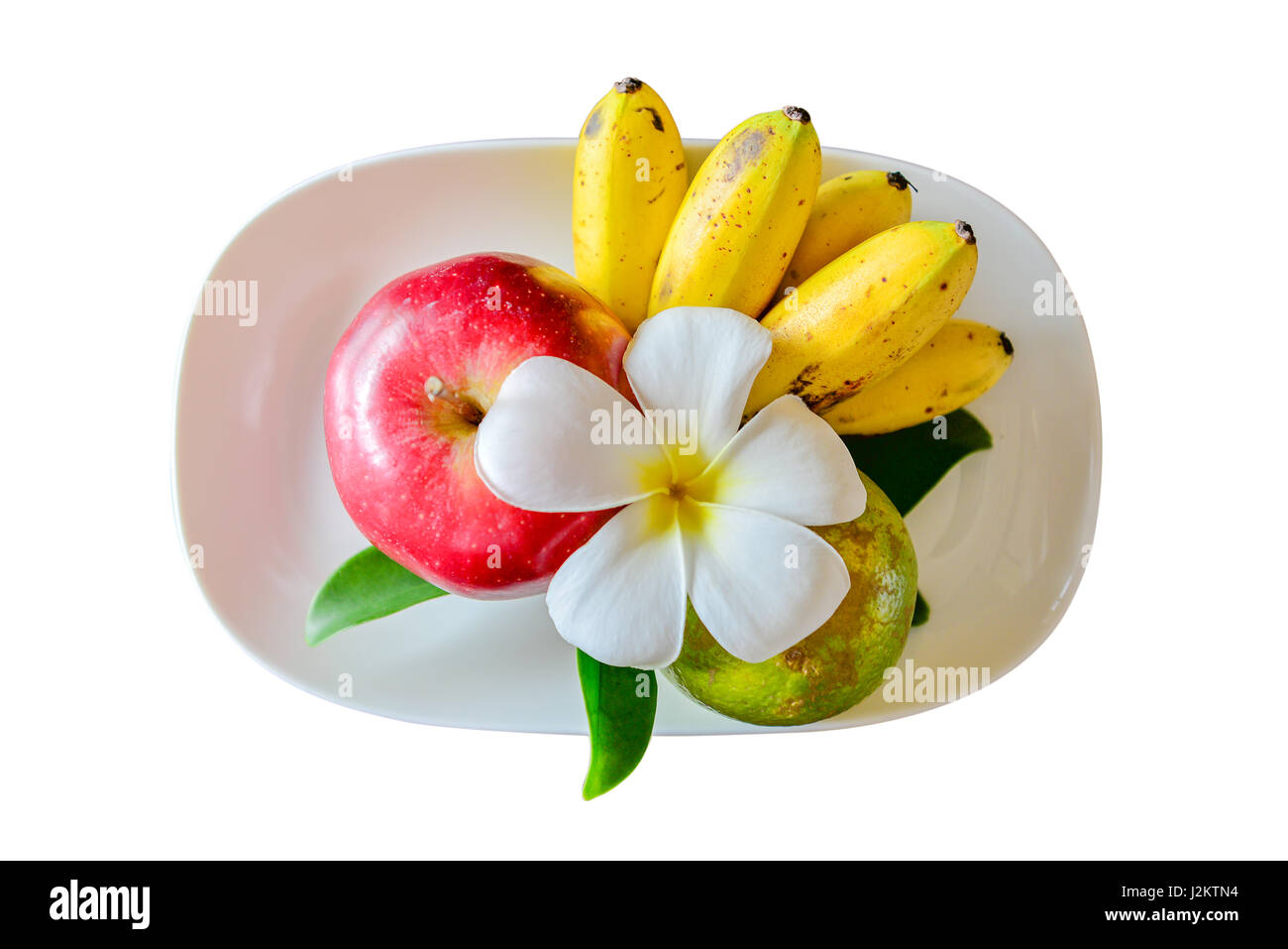 Les pommes et les bananes sur un plat blanc, isolé sur fond blanc. Vue de dessus, chemins de détourage inclus Banque D'Images