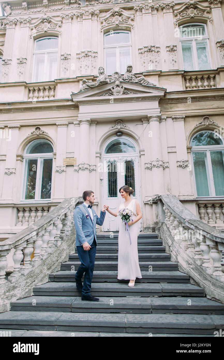 Belle paire juste marié à la baisse par d'anciens escaliers près de l'ancien palais d'autriche Banque D'Images