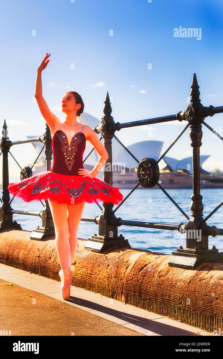 Mettre en place les jeunes en concert tutu ballerine rouge excercising et pratiquer sur rue près de port de Sydney The Rocks et Circular Quay dans la lumière du matin. Banque D'Images