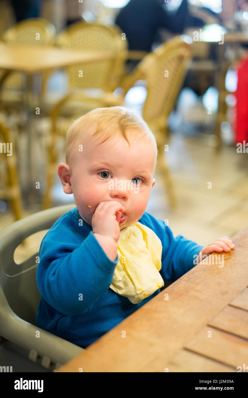 Huit mois bébé garçon mangeant à la Vénus Dartington Cider Press , café, TOTNES, Devon, Angleterre, Royaume-Uni Banque D'Images