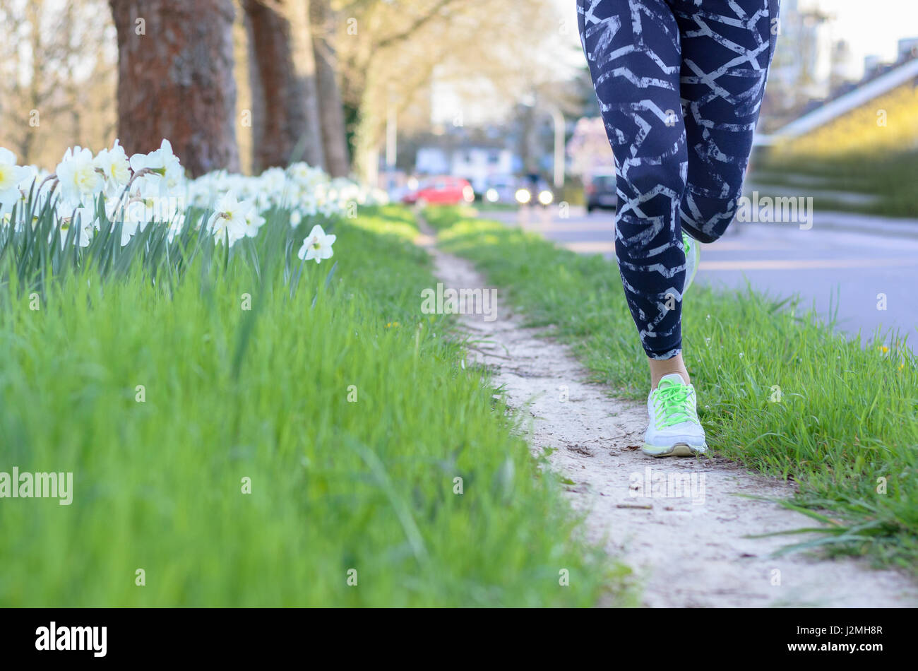 L'exécution de jambes musclées d'un jeune athlète de la formation ou l'entraînement dans une rue d'un low angle view le long de l'allée Banque D'Images