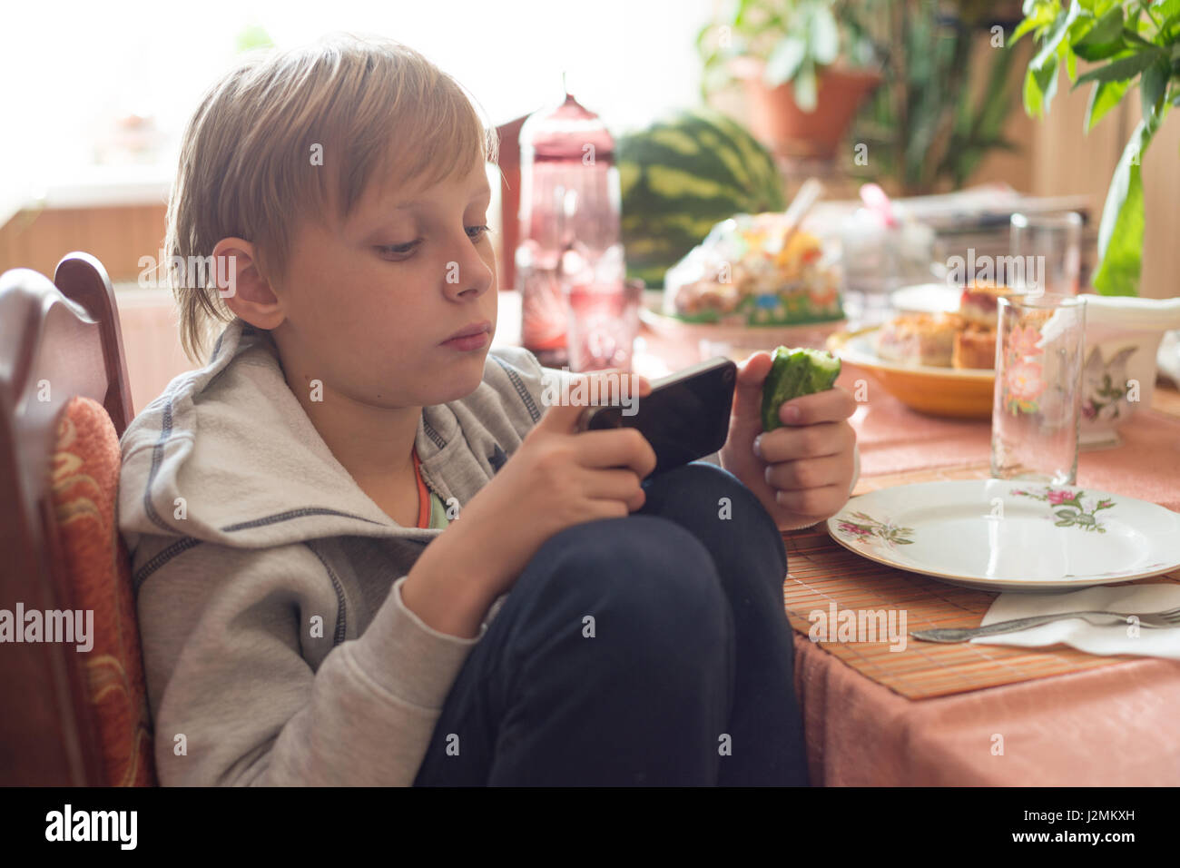 Garçon utilise un smartphone à la maison Banque D'Images