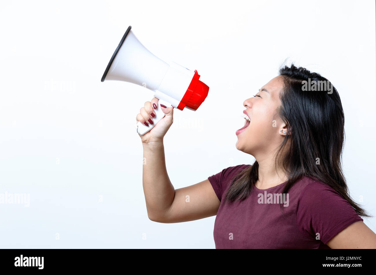 Jeune femme criant dans un mégaphone, vue latérale sur un rassemblement de conceptuel blanc ou de la contestation Banque D'Images