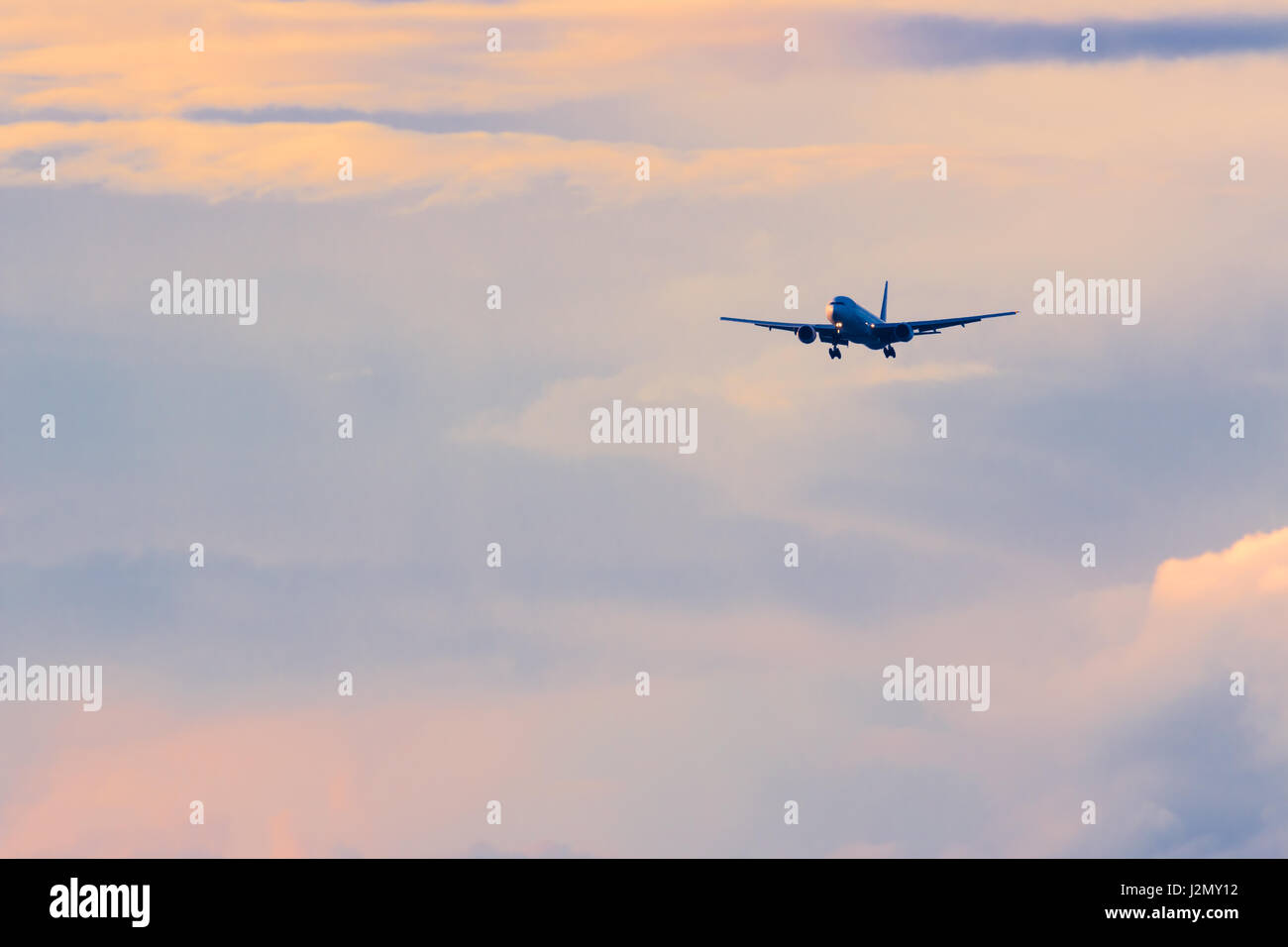 Avion de transport commercial de passagers à l'atterrissage contre belle de soleil colorés, de couleur et de contraste Banque D'Images