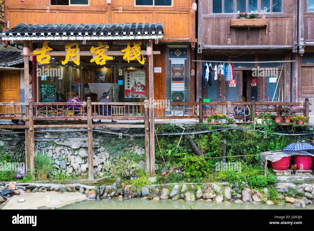 Zhaoxing, Guizhou, en Chine, un village de la minorité Dong. Boutiques et maisons de la petite rivière qui traverse le village. Banque D'Images