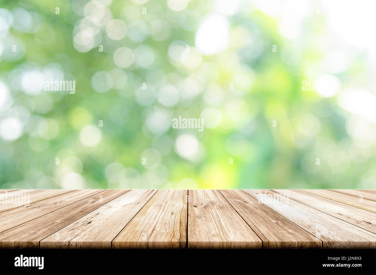 Table en bois vide haut avec jardin vert floue. arrière-plan peut être utilisé l'affichage des produits. Banque D'Images